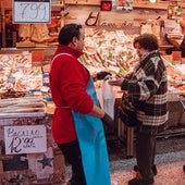 Una mujer recoge su compra en la pescadería.