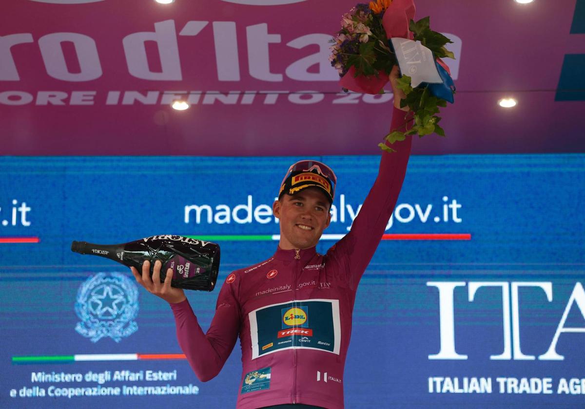 Mads Pedersen, vestido de rosa en el podio, celebra su victoria en la quinta etapa.
