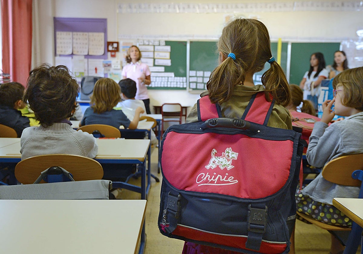 Un grupo de alumnos atienden las explicaciones de su profesora.