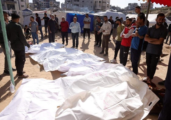 Ciudadanos velan los cuerpos de los palestinos muertos en un ataque israelí frente al hospital indonesio en Beit Lahia, en el norte de Gaza.