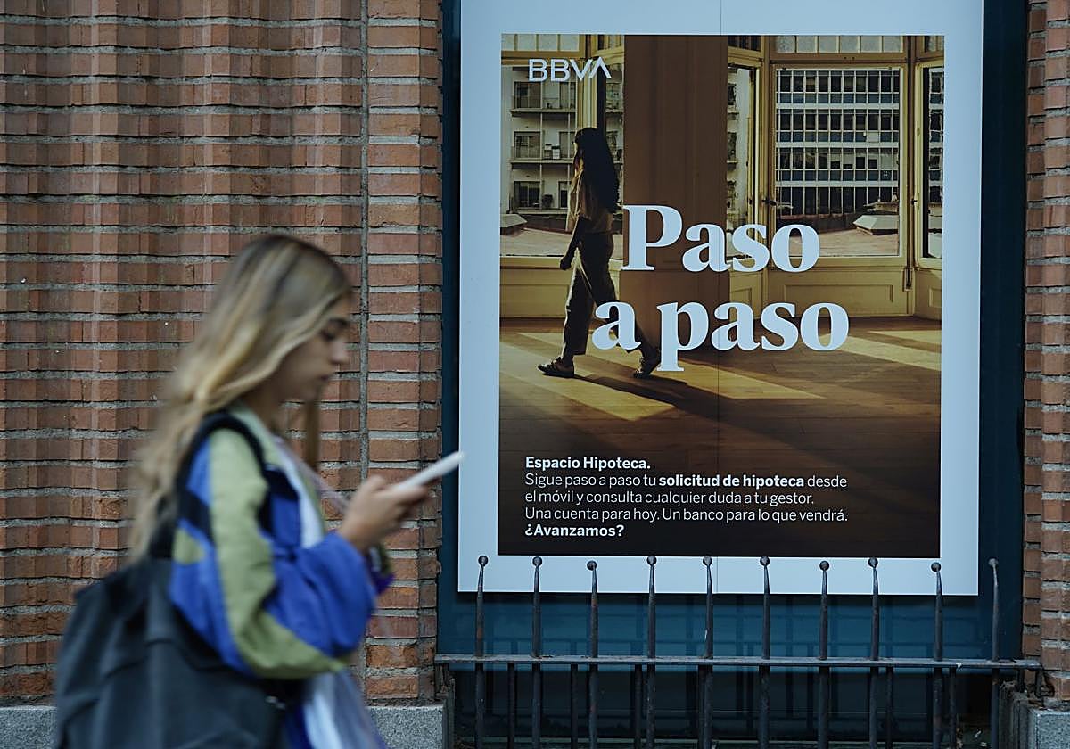 Una mujer frente a una entidad bancaria.