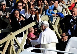 El Papa León XIV bendice a un niño.