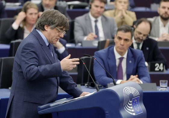 Carles Puigdemont, bajo la mirada del presidente Pedro Sánchez en una sesión del Europarlamento en diciembre de 2023.