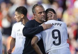 Hansi Flick consuela a Kylian Mbappé tras el clásico liguero disputado el 11 de mayo en Montjuic.
