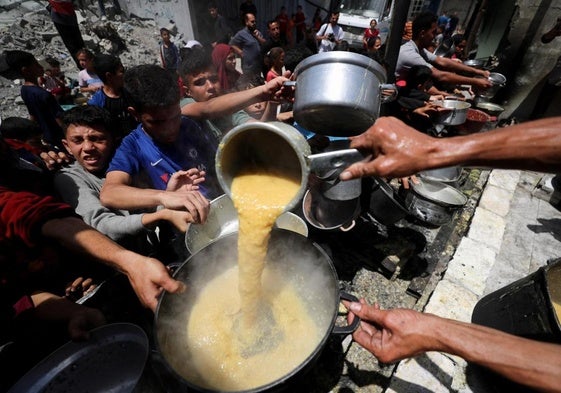 Varios gazatíes tratan de recoger algo de comida en Jabalia, en el norte de la Franja.