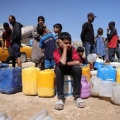 Familias con niños hacen cola para recoger agua en un campamento para desplazados en Ciudad de Gaza.