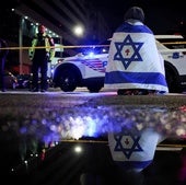 Un hombre con una bandera de Israel en el lugar donde se produjo el asesinato.