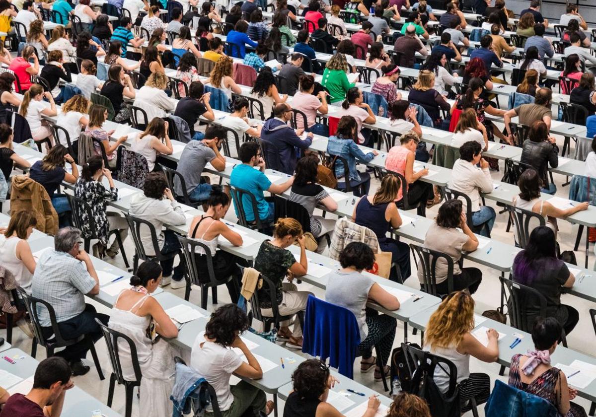Un grupo de personas examinándose de unas oposiciones a la administración pública.