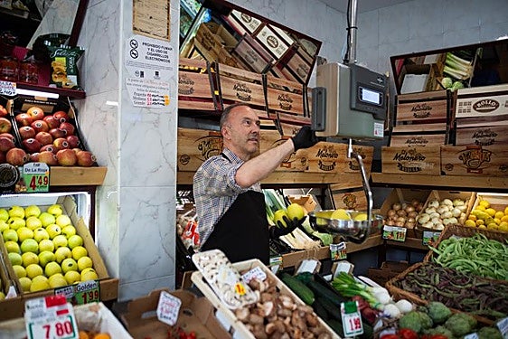 Frutero despacha en su negocio.