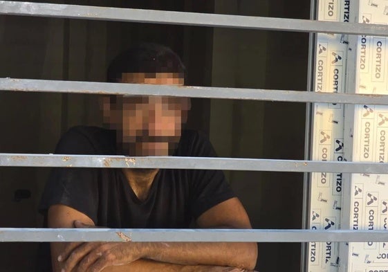 El detenido, mientras esperaba a los bomberos en el piso en el que fue sorprendido.