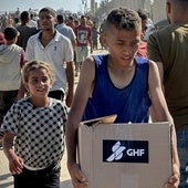 Un joven gazatí carga una caja con alimentos tras haber sido invadido el martes el centro de reparto de la organziación GHF.