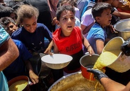 Un grupo de palestinos hace cola para recibir comida en un punto de distribución en Ciudad de Gaza.