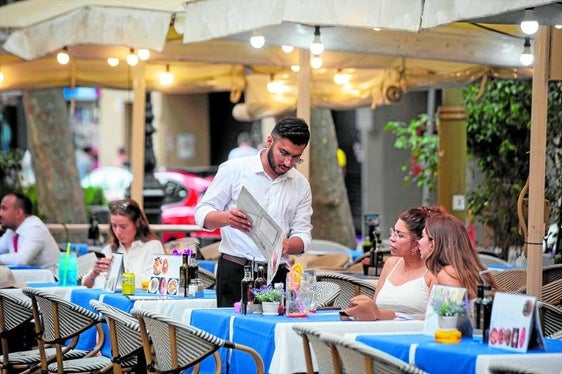 Un camarero atiende a una mesa en las Ramblas, a 15 de junio de 2022, en Barcelona.