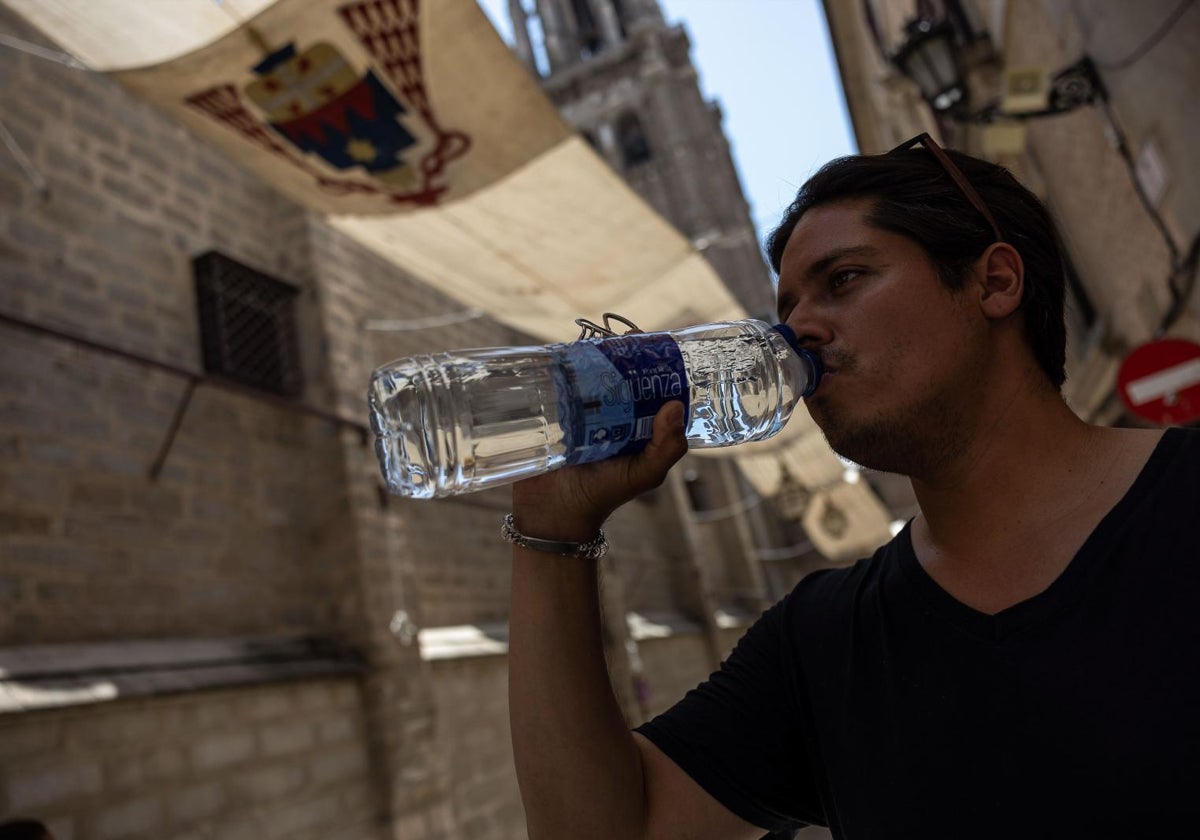 Un joven se refresca en Toledo.