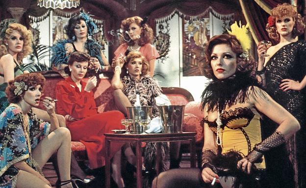 La película de Vicente Escrivá 'Niñas... al salón', del año 1977, con sus actrices, entre ellas Sandra Alberti, sentada al fondo con un chal de plumas de marabú y un cigarrillo en la mano.