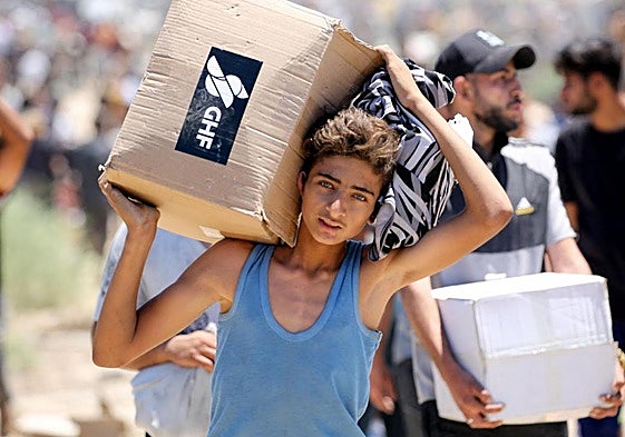 Un niño transporta una caja de suministros de ayuda de la Fundación Humanitaria de Gaza.