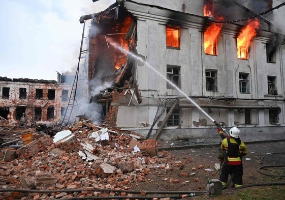 Los bomberos tratan de apagar el incendio en un edificio atacado.