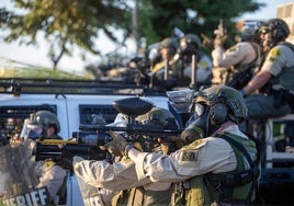 Agentes federales se enfrentan a manifestantes en una calle de Los Ángeles.
