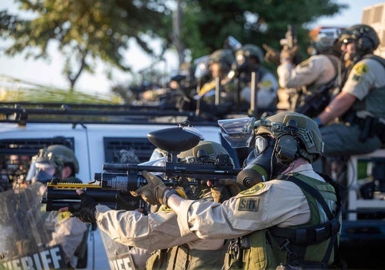 Agentes federales se enfrentan a manifestantes en una calle de Los Ángeles.