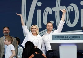 Marine Le Pen y Jordan Bardella saludan en la convención ultra, con Abascal al fondo.