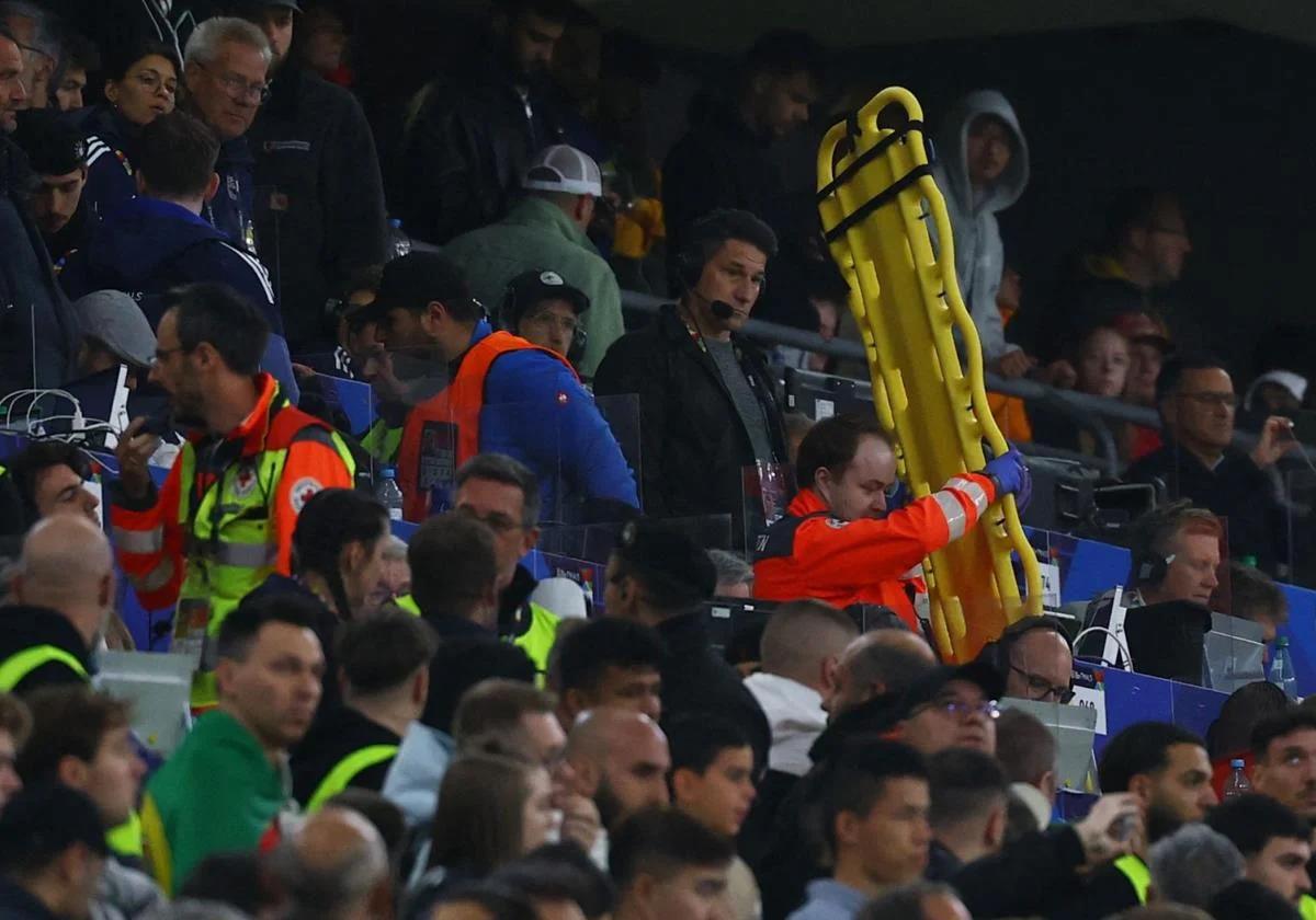 Varios sanitarios atienden a la persona que acabó falleciendo, ayer, en el Allianz Arena