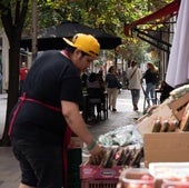 Un dependiente coloca fruta en un pequeño comercio.