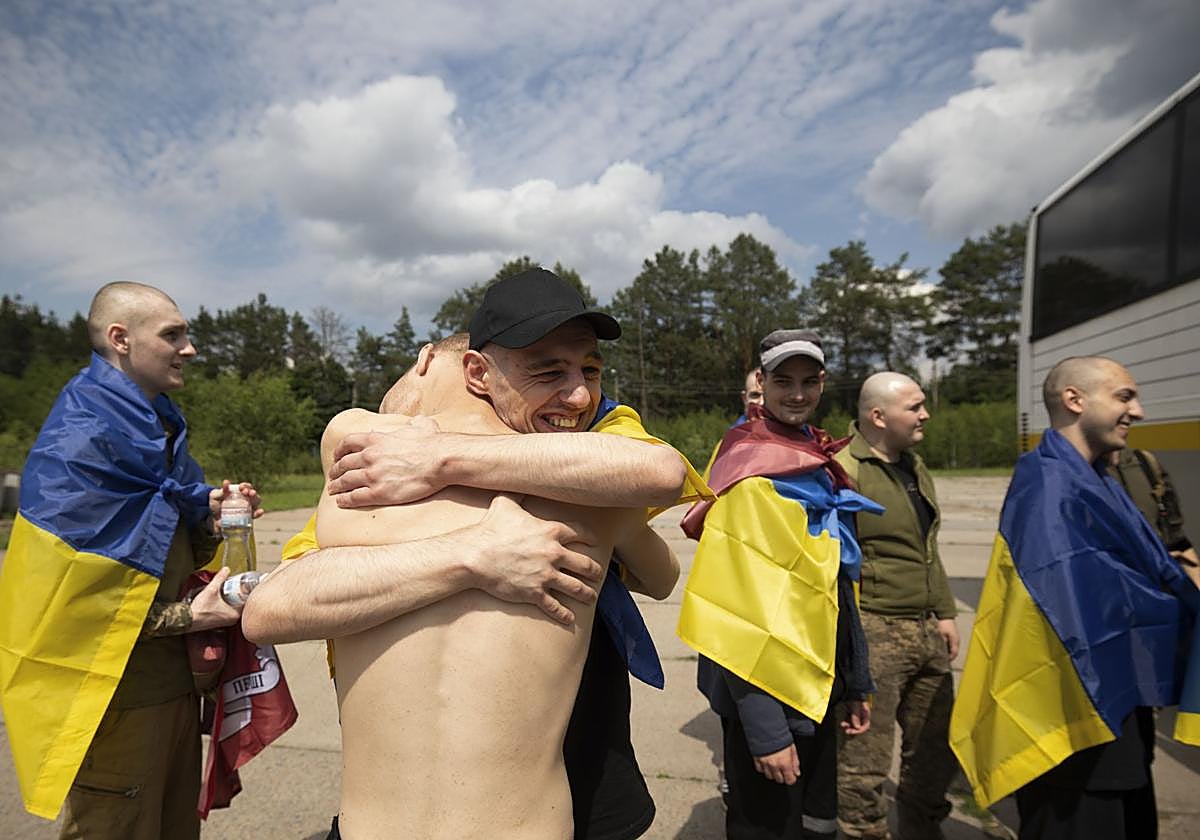 prisioneros de guerra ucranianos celebran su regreso tras un intercambio de prisioneros con Rusia, en una ubicación no revelada.
