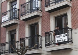 Un cartel de un edificio donde se venden y alquilan viviendas.