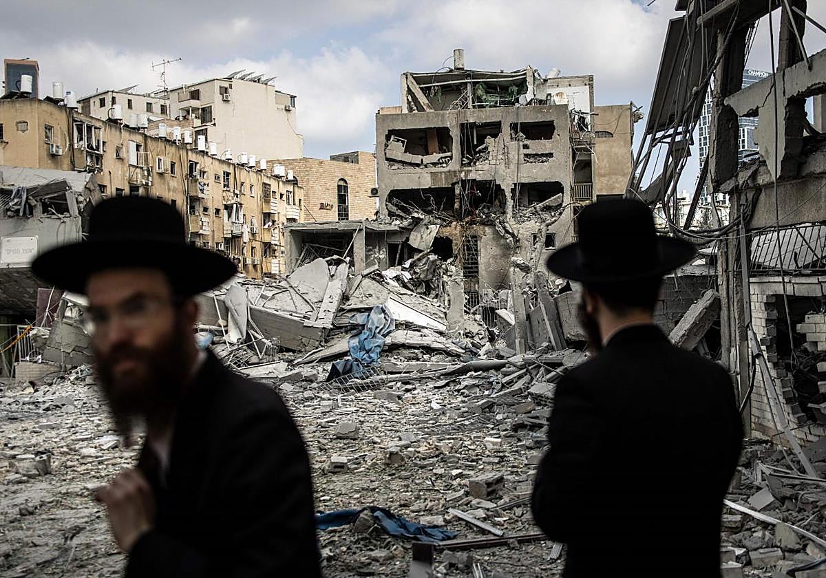Ultraortodoxos contemplan los daños causados por un misil iraní en su barrio, al sur de Tel Aviv.