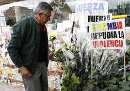 Un hombre observa un altar por Uribe Turbay frente a la Fundación Santa Fe de Bogotá.