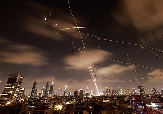 Las estelas de las defensas antiaéreas israelíes y de los misiles iraníes, en la noche de Tel Aviv.