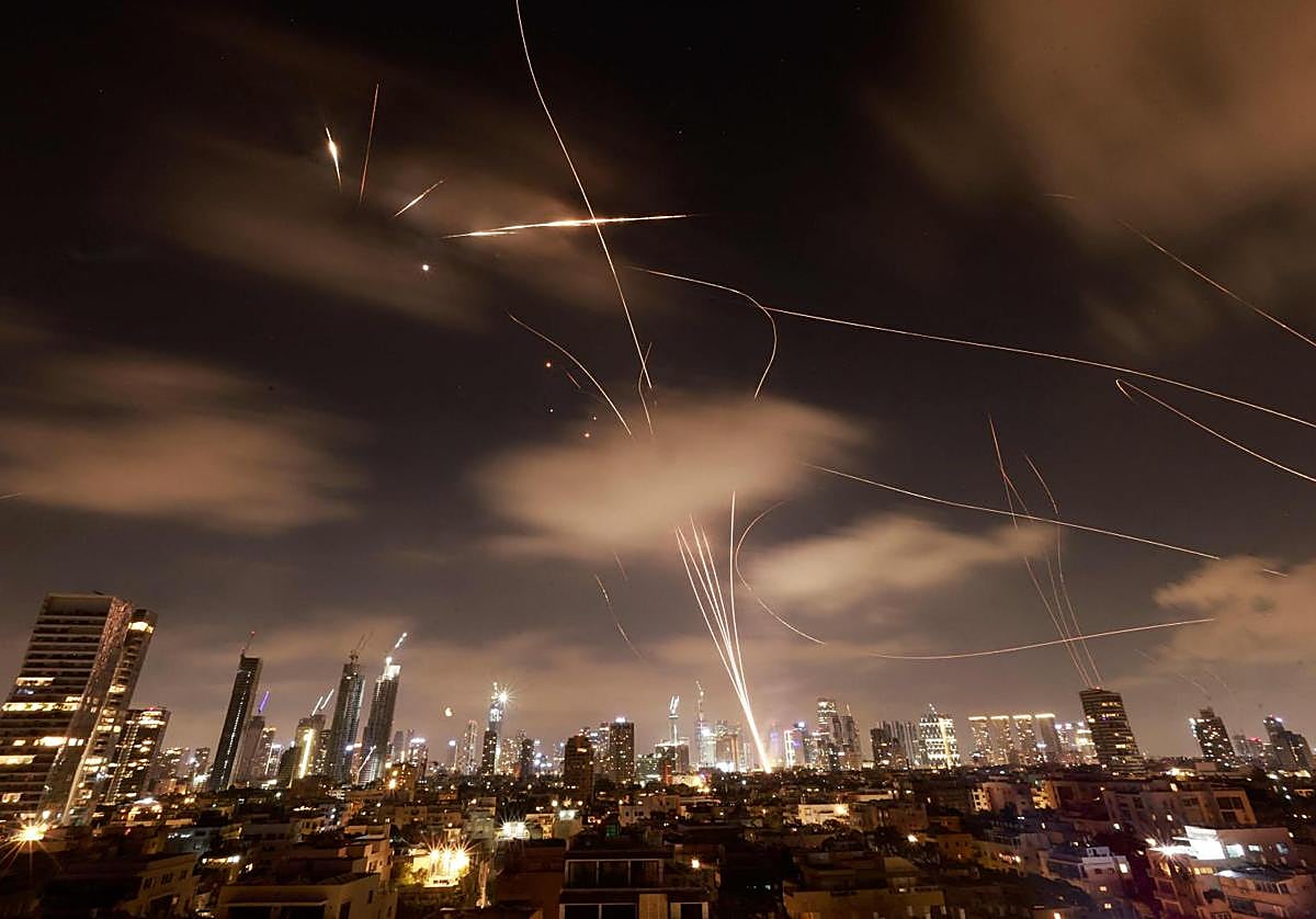 Las estelas de las defensas antiaéreas israelíes y de los misiles iraníes, en la noche de Tel Aviv.