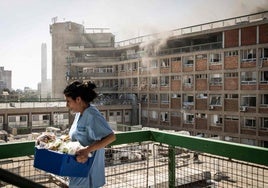 Un empleada del hospital de Soroka, en Israel, traslada material tras el bombardeo sobre el centro, que causó grandes daños materiales.
