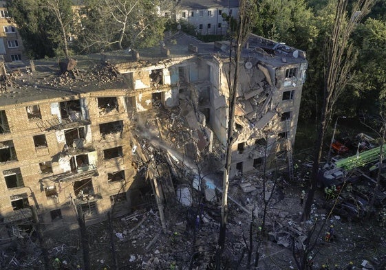 Los servicios de emergencia trabajan en el lugar donde un cohete impactó contra un edificio residencial de cinco plantas en Kiev.
