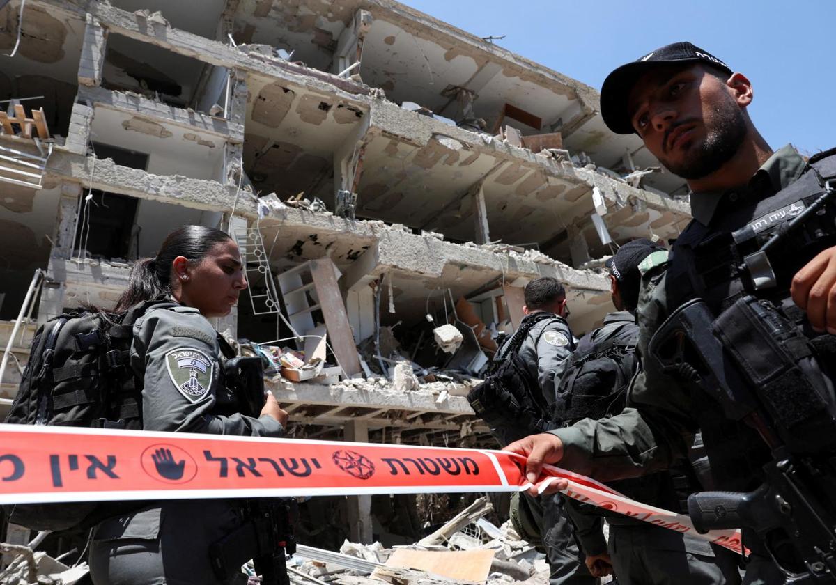 Soldados israelíes acordonan un edificio destruido por un misil iraní.