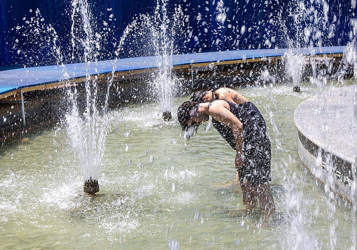 Unos jóvenes se refrescan en una fuente en Logroño.