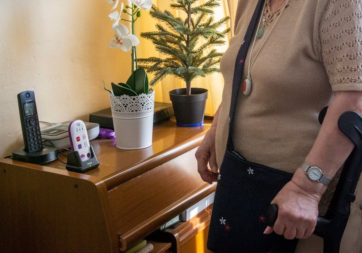 Una mujer dependiente, junto a sus dispositivos de teleasistencia.