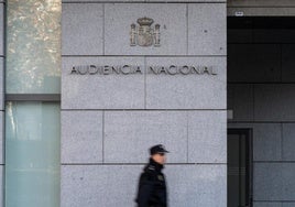 Un policía nacional vigila la puerta de acceso a la Audiencia Nacional.