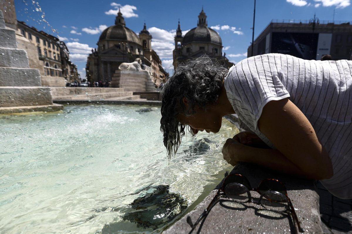 Una joven se refresca en una fuente,