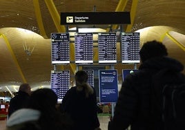 Varias personas en un aeropuerto esperando la salida de un vuelo.