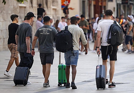 Varios turistas con sus maletas por el centro de Valencia.