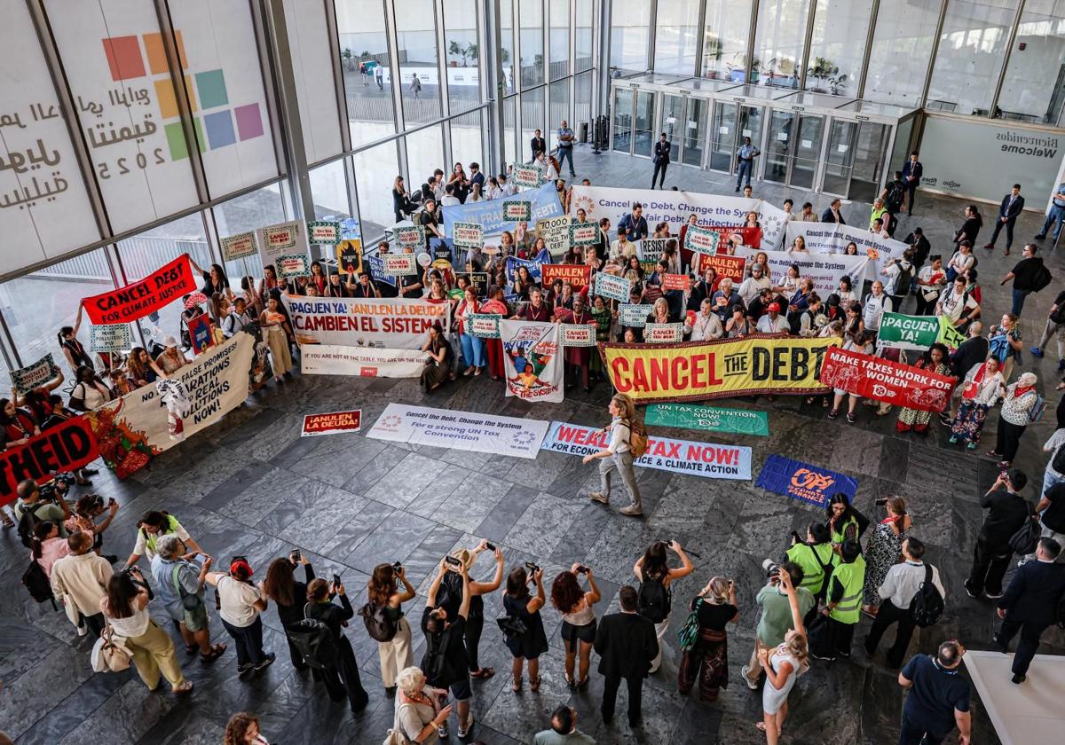 Miembros de organizaciones civiles protestan este jueves en la cumbre de la ONU de Sevilla por la cancelación de la deuda a los países en vías de desarrollo.