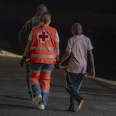 Una trabajadora de Cruz Roja, con un menor migrante en la isla de El Hierro.
