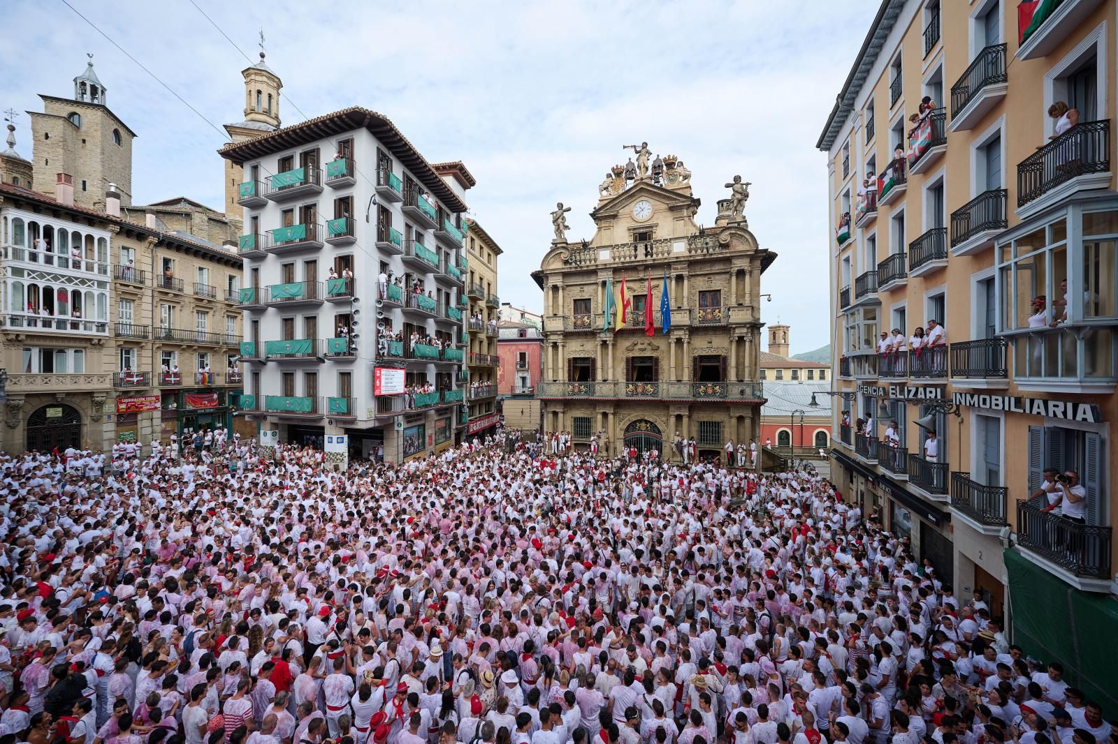 El Casco Viejo de Pamplona se ha llenado de vida: peñas en movimiento, pasacalles y miles de personas luciendo el clásico atuendo blanco y rojo, ese que con el paso de las horas va oscurenciéndose.