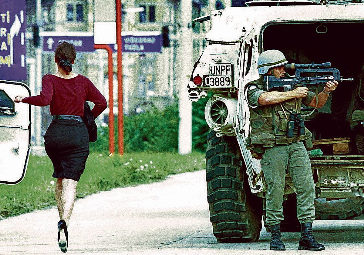 Imagen principal - Una mujer corre mientras un soldado la protege de un francotirador, un puente colgante reemplaza al antiguo Mostar, en Bosnia en 1995, y Radovan Karadzic con uniforme militar. 
