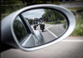 Motoristas vistos a través del retrovisor de un coche.
