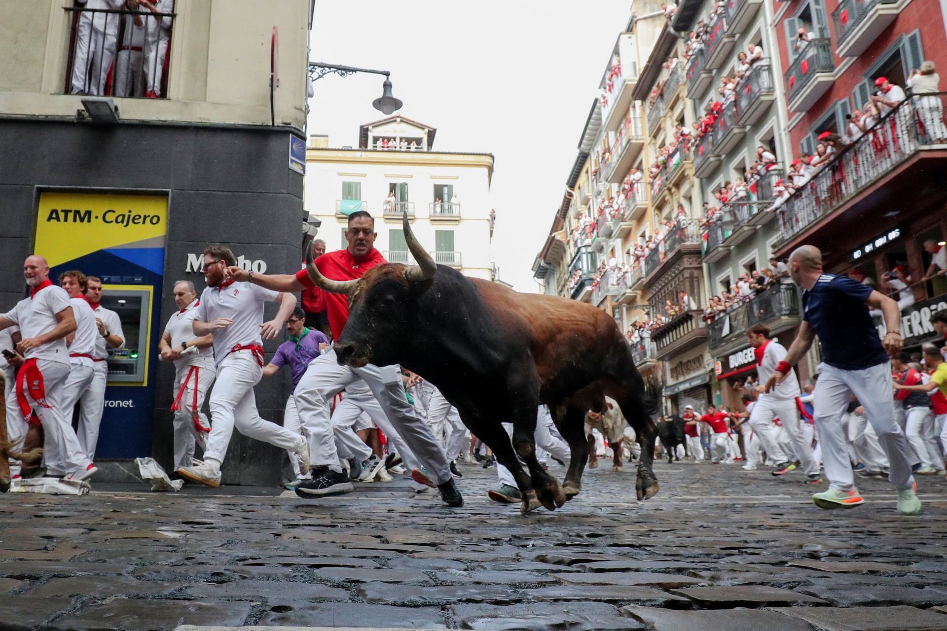 Participantes corren durante el encierro en la esquina de Mercaderes.