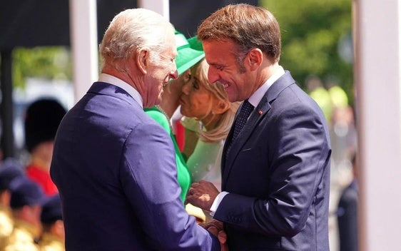 Carlos III y Emmanuel Macron se saludan afectuosamente en Windsor.