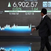 Un operador camina ante las patallas de cotización de la Bolsa de Indonesia.