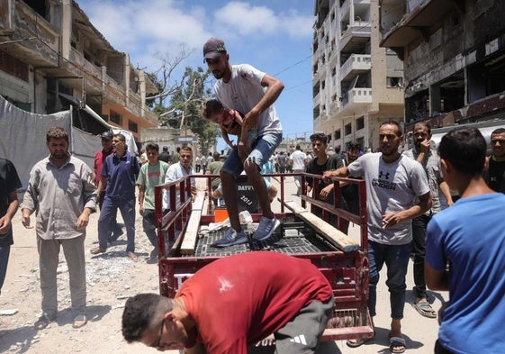 Un hombre traslada a un niño herido tras un bombardeo israelí en Gaza.
